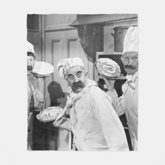 Three chefs holding pies for a fight in the kitche fleece blanket