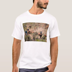 Three cowboys and cowgirls driving cattle T-Shirt