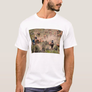 Three cowboys and cowgirls driving cattle T-Shirt