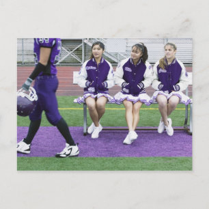Three female cheerleaders (16-18) watching postcard