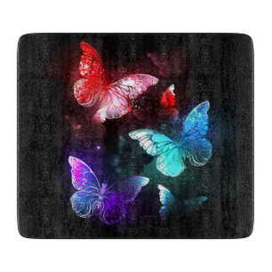 Three Glowing Butterflies on night background Cutting Board