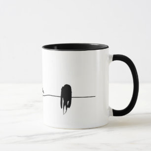 Three little birds sitting on a wire mug