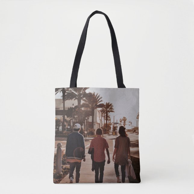 Three persons walking near palm trees tote bag (Front)