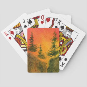 Three pines at fiery sunrise on a sheer cliff playing cards
