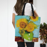 Three Sunflowers | Vincent van Gogh Tote Bag<br><div class="desc">Three Sunflowers (1888) by Vincent van Gogh is a vibrant still life that showcases the artist’s signature thick brushstrokes and bold use of colour. The painting features three sunflowers in a simple vase, their golden petals contrasting against the aqua blue background. Van Gogh's vivid yellow palette brings energy and life...</div>