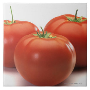 Three tomatoes on counter, close-up tile