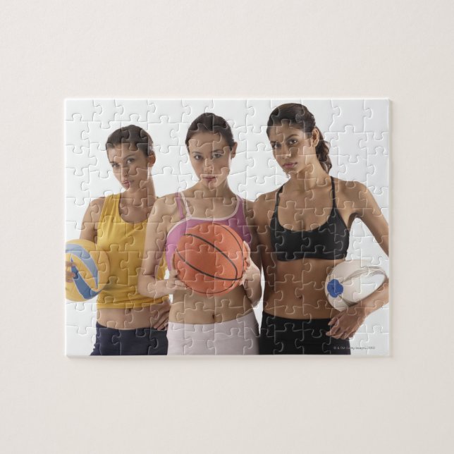 three women of different race, holding jigsaw puzzle (Horizontal)
