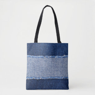 Torn denim: blue jeans fabric. tote bag