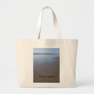 Tote features shore with footprints in the sand.