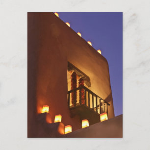 Traditional farolitos light up adobe structures postcard
