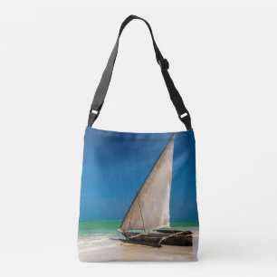 Traditional fishing boat on the beach crossbody bag