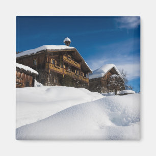 Traditional wooden cabins in de snow magnet