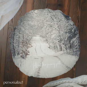 Trail through a snow-covered winter forest round cushion