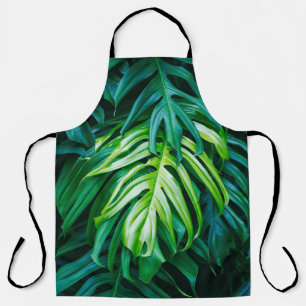 Tropical green leaves on dark background, nature s apron