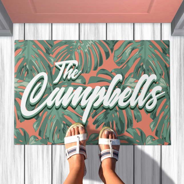 Tropical Leaves Script Green Family Name Doormat (Doormat with green leaves on orange background. Text overlay says your family name)