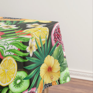 Tropical mix-fruit, flowers and leaves on black tablecloth