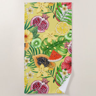 Tropical mix-fruit, flowers and leaves on yellow beach towel