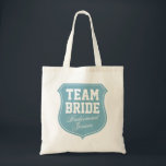 Turquoise Team Bride tote bags for wedding party<br><div class="desc">Turquoise Team Bride tote bags for wedding party. Personalizable with name. Cute gift idea for bride,  bridesmaids,  maid of honour,  mum,  sister,  friends etc. Pink emblem badge design for wedding party,  bridal shower,  bachelorette girls night out. Elegant script letters. Turquoise blue and white colours.</div>
