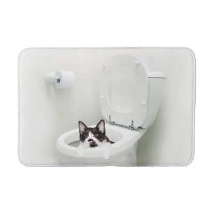 Tuxedo kitty in toilet bath mat
