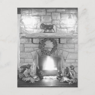 Two girls sitting by a fireplace at Christmas Holiday Postcard