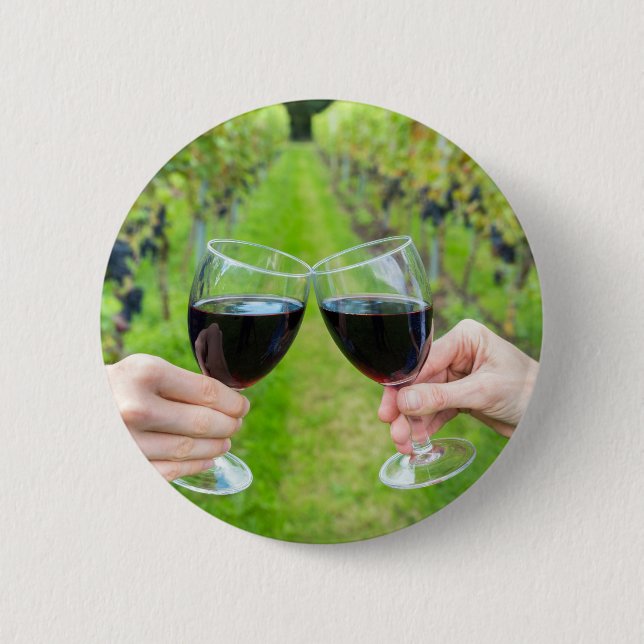 Two hands toasting with wine glasses in vineyard 6 cm round badge (Front)