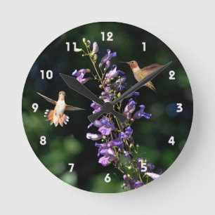 Two Hummingbirds In Flight With Flowers Wall Clock