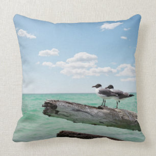 Two seagulls sitting on a dead tree sticking out cushion