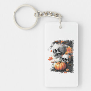 Two skulls and a pumpkin among flowers. key ring