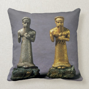 Two statuettes of men carrying offerings of goats, cushion