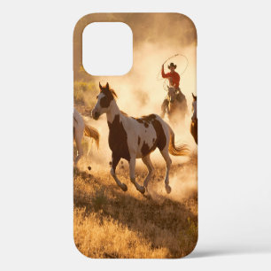Two western cowboys riding horses, roping wild hor iPhone 12 case