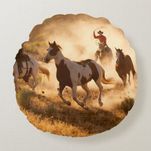 Two western cowboys riding horses, roping wild hor round cushion