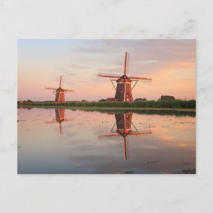 Two windmills with reflection at sunset postcard