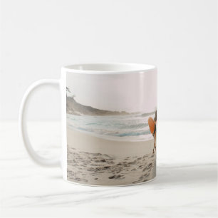 Two women walking towards the ocean carrying surfb coffee mug