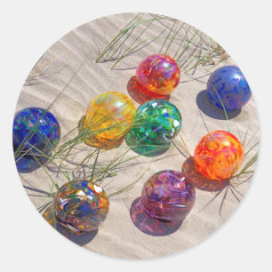 USA, Oregon. Colourful Glass Floats On Sand Dune Classic Round Sticker