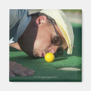USA, Utah, Orem, Man blowing air to push golf Magnet