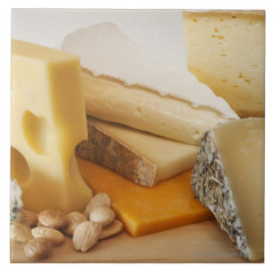 Various cheeses on chopping board ceramic tile