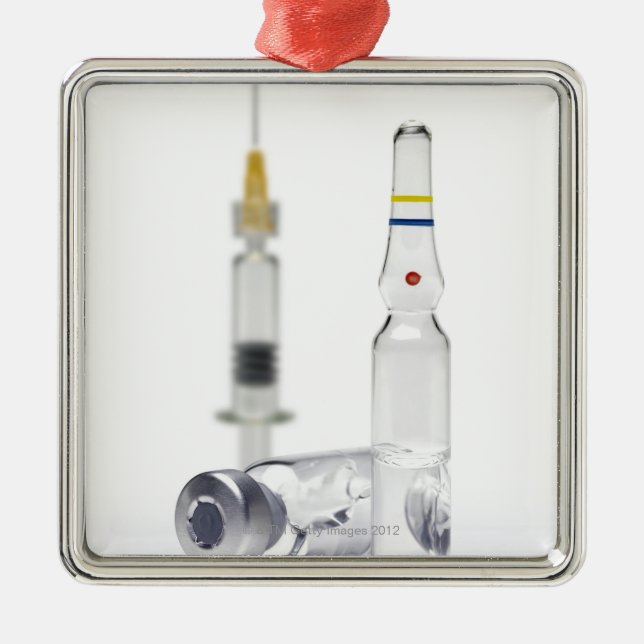Vials containing medicine for injections and metal ornament (Front)