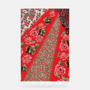 Vibrant red fabric featuring intricate floral and acrylic sign