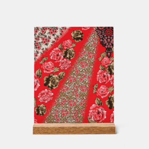 Vibrant red fabric featuring intricate floral and  acrylic sign