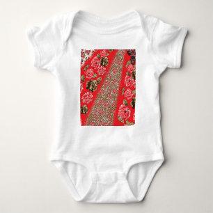 Vibrant red fabric featuring intricate floral and baby bodysuit