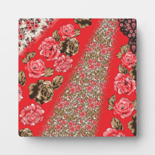 Vibrant red fabric featuring intricate floral and  plaque