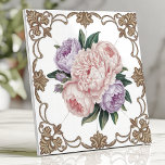 Victorian Peony Bouquet with Gold Scrollwork Ceramic Tile<br><div class="desc">This exquisite Victorian-inspired ceramic design features a delicate bouquet of pink and lavender peonies at its centre, surrounded by intricate golden scrollwork on a crisp white background. The floral arrangement radiates timeless elegance, perfect for adding a touch of luxury to kitchens, bathrooms, or decorative accents. The ornate detailing and soft...</div>