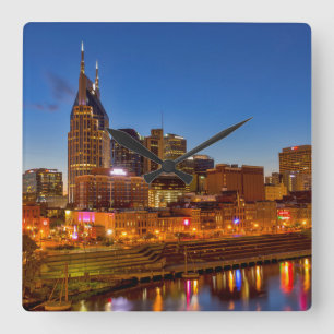 View of the city skyline at dusk square wall clock