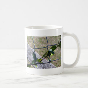 vine on a chain link fence life finds a way coffee mug