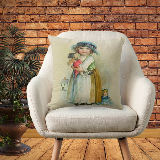 Vintage Little Girl Chubby Cheeks Hat Dolls Cushion (Little girl blue hat holding dolls on tan decorative pillow.)