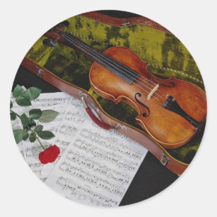Violin and red rose on black background classic round sticker