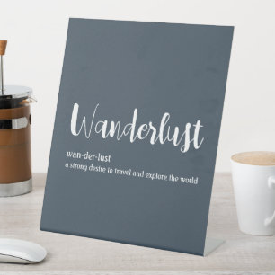 Wanderlust definition white grey blue colour pedestal sign