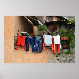 Washed clothes drying on the street side in villag poster