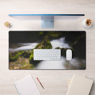 Water flowing through enchanted mossy forest desk mat