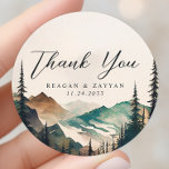 Watercolor Mountains Pine Forest Wedding Thank You Classic Round Sticker<br><div class="desc">Seal your gratitude with the tranquil beauty of the Watercolor Mountains Pine Forest Wedding Thank You Classic Round Sticker. This sticker, printed on durable material, features a serene watercolor scene of mountains and a pine forest. A heartfelt 'Thank You' message, written in modern typography, graces the centre of the sticker....</div>
